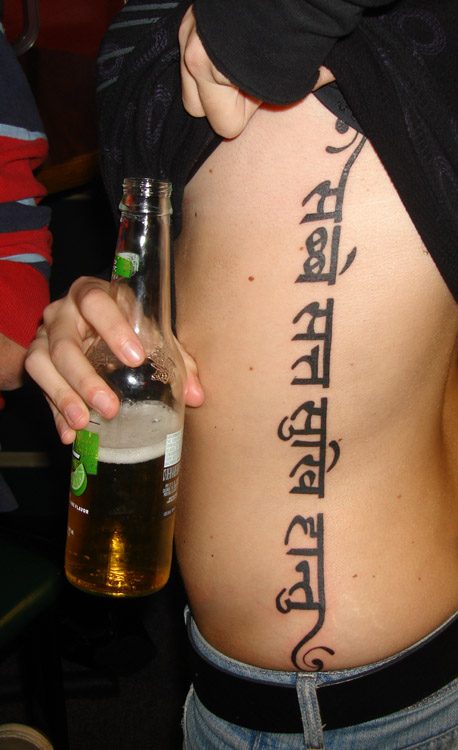 The tattoo is in fact the Tibetan Buddhist mantra, 'Om Mani Padme Hum'- by
